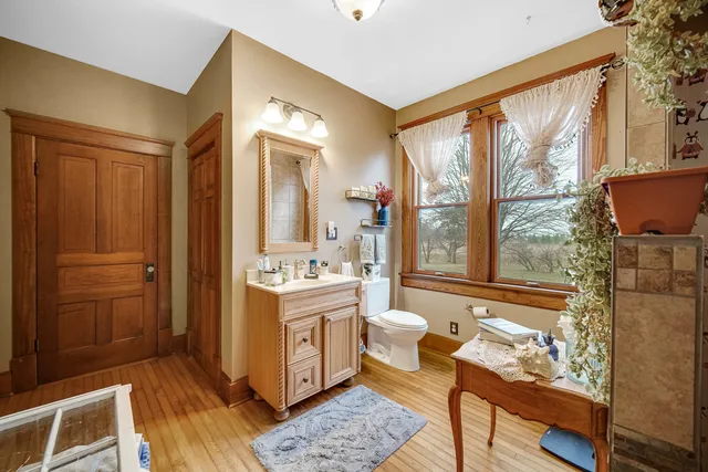 a living room with a couch and a dining table with wooden floor