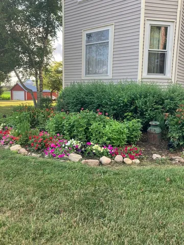 a view of a garden with a house in the background