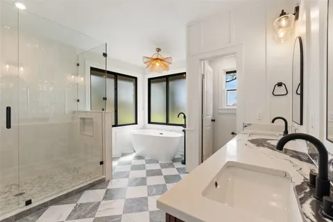 a bathroom with a double vanity sink mirror and bathtub