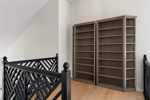 a spacious bedroom with a bed a large window with table and chairs