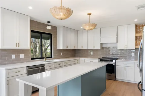 a kitchen with a center island appliances and cabinets