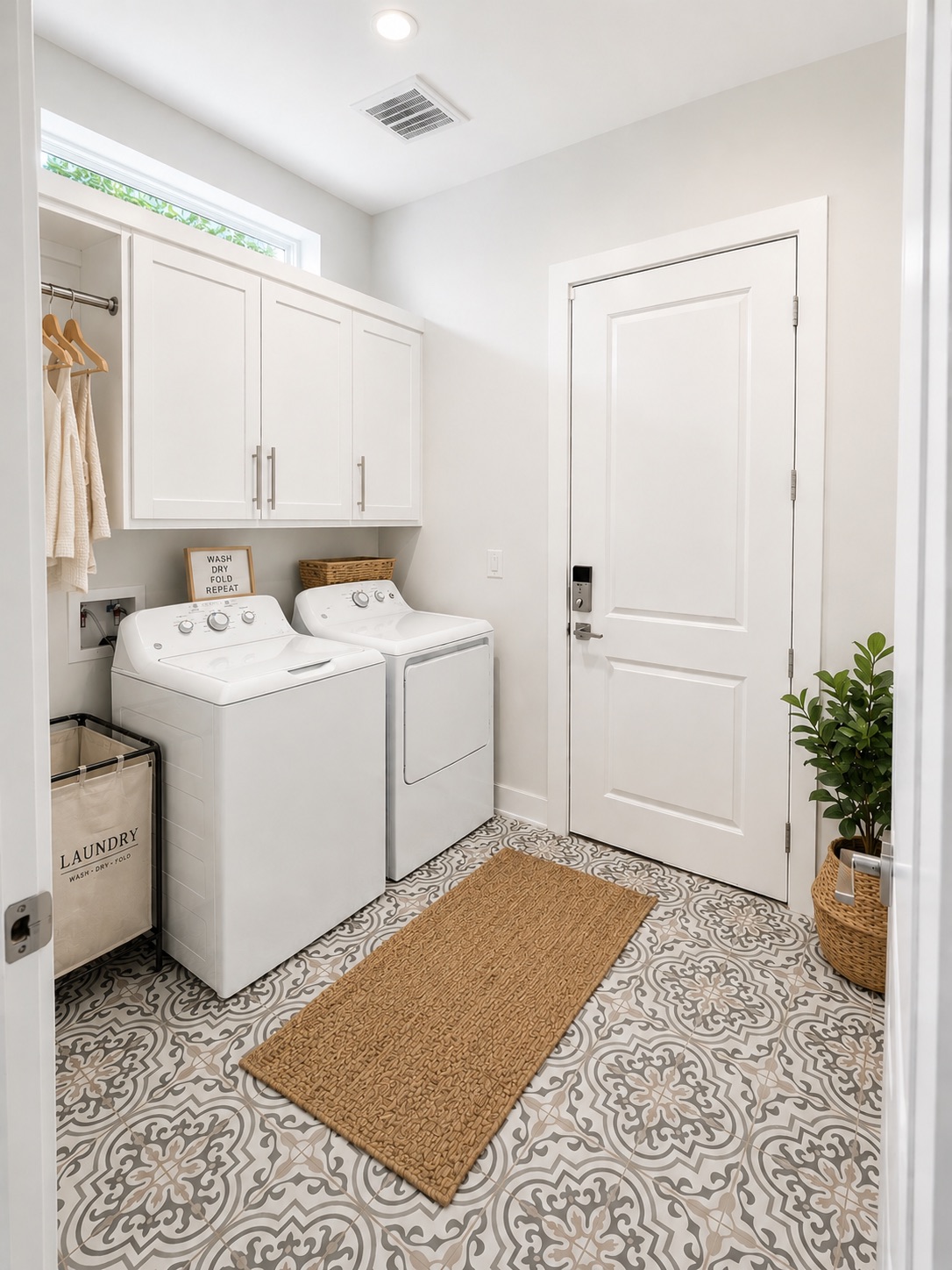 1719 Bunche Road Austin, TX 78721 - Photo 20 of 22 A well-appointed utility room features a washer and dryer, complemented by elegant patterned tile flooring.