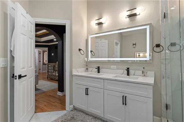a living room with furniture a flat screen tv and kitchen view