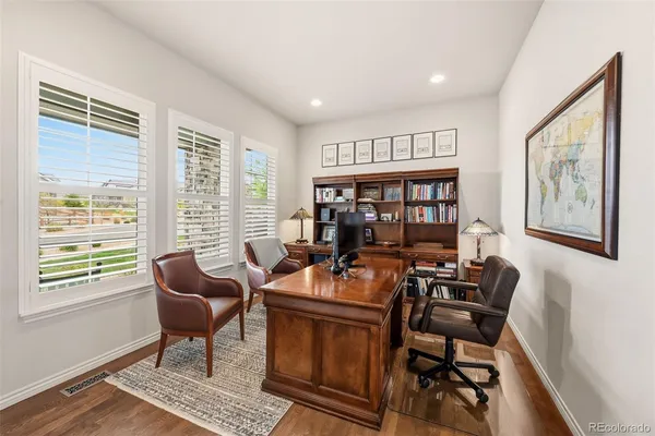 a work room with furniture wooden floor and a window