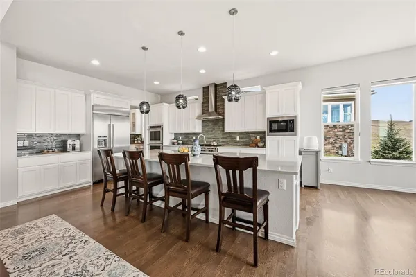 a open dining room with stainless steel appliances kitchen island granite countertop a dining table chairs and view living room