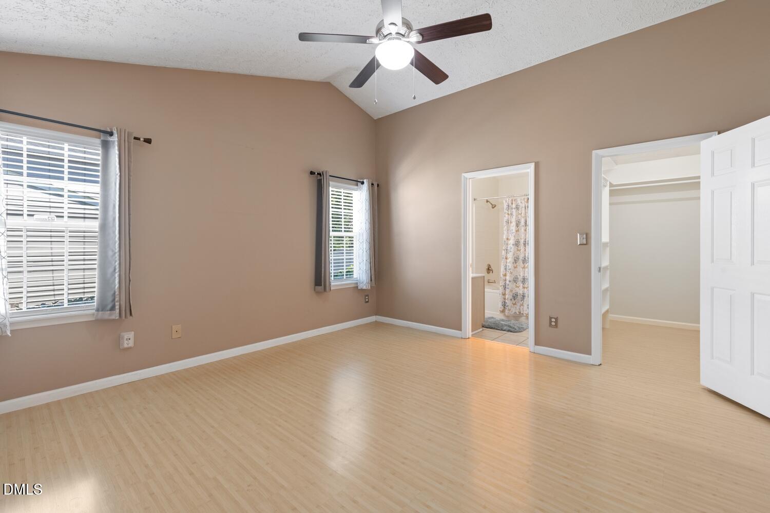 6900 Glenroy Court Raleigh, NC 27616 - Photo 6 of 30 an empty room with wooden floor chandelier fan and windows