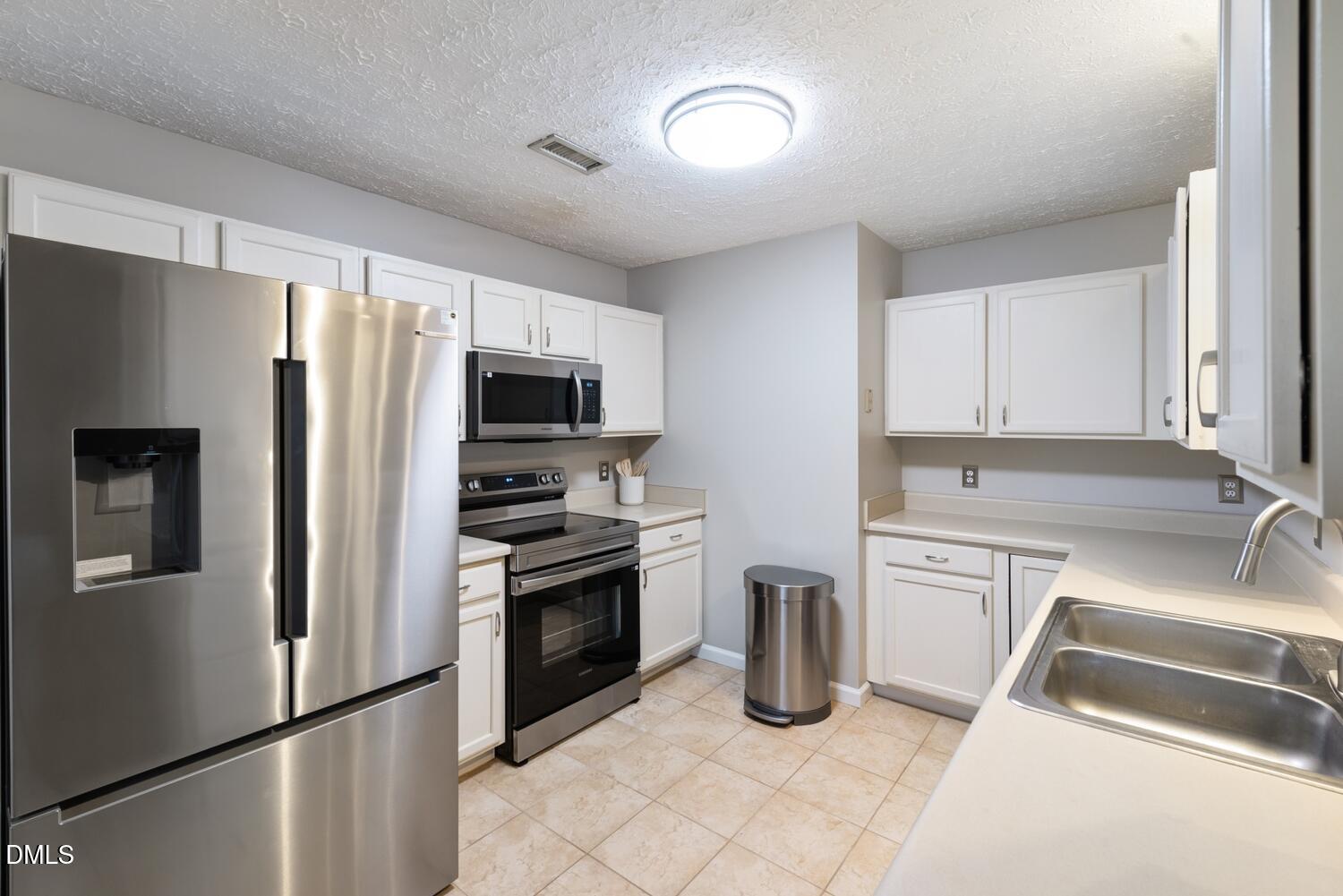 6900 Glenroy Court Raleigh, NC 27616 - Photo 10 of 30 a kitchen with granite countertop a refrigerator stove and sink