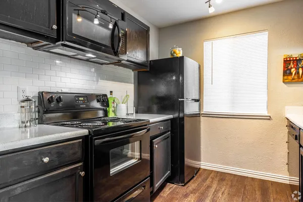 a kitchen with stainless steel appliances a refrigerator a stove a microwave and cabinets