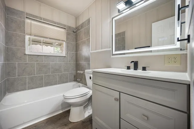 a bathroom with a bathtub shower sink vanity and toilet