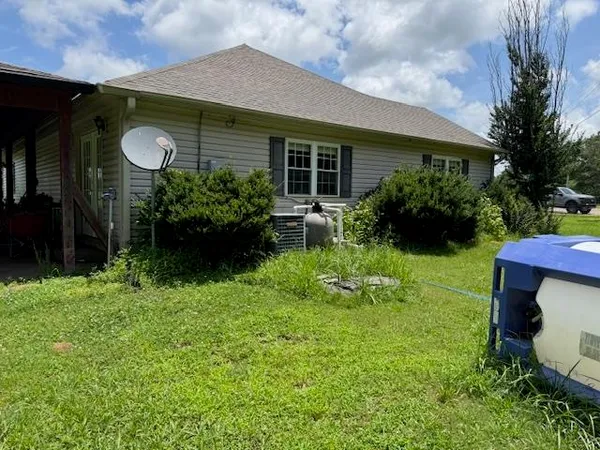 a view of house with a yard and potted plants