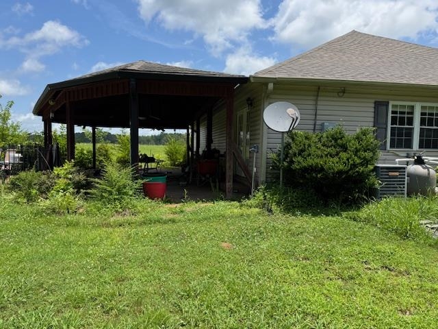 110 Falcon Cove Middleton, TN 38052 - Photo 4 of 20 a backyard of a house with table and chairs under an umbrella
