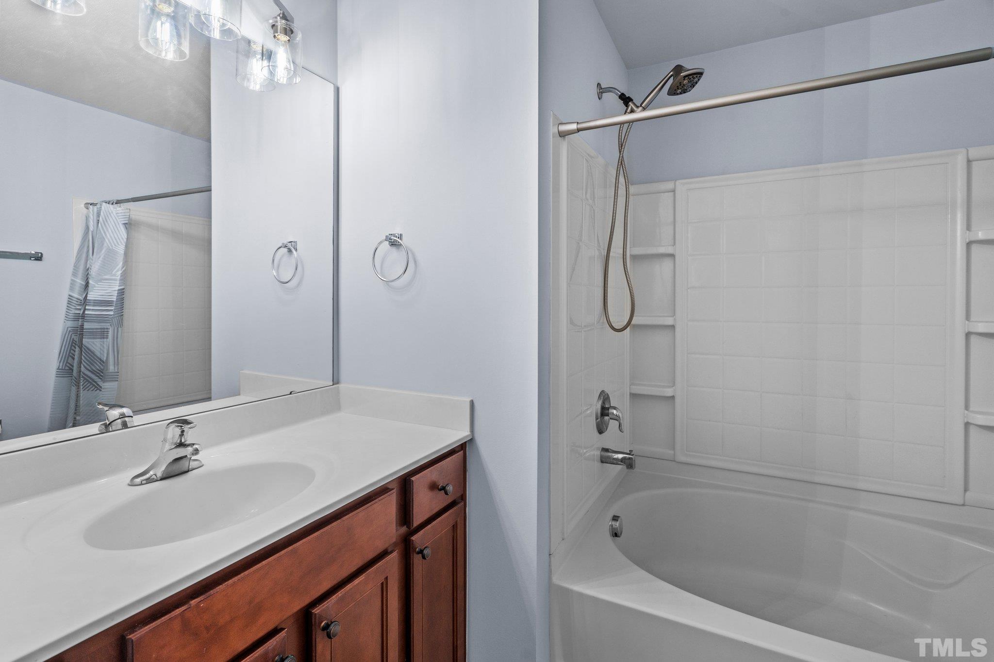3012 Berkeley Springs Place Raleigh, NC 27616 - Photo 13 of 22 a bathroom with a granite countertop sink a mirror a vanity and a bathtub