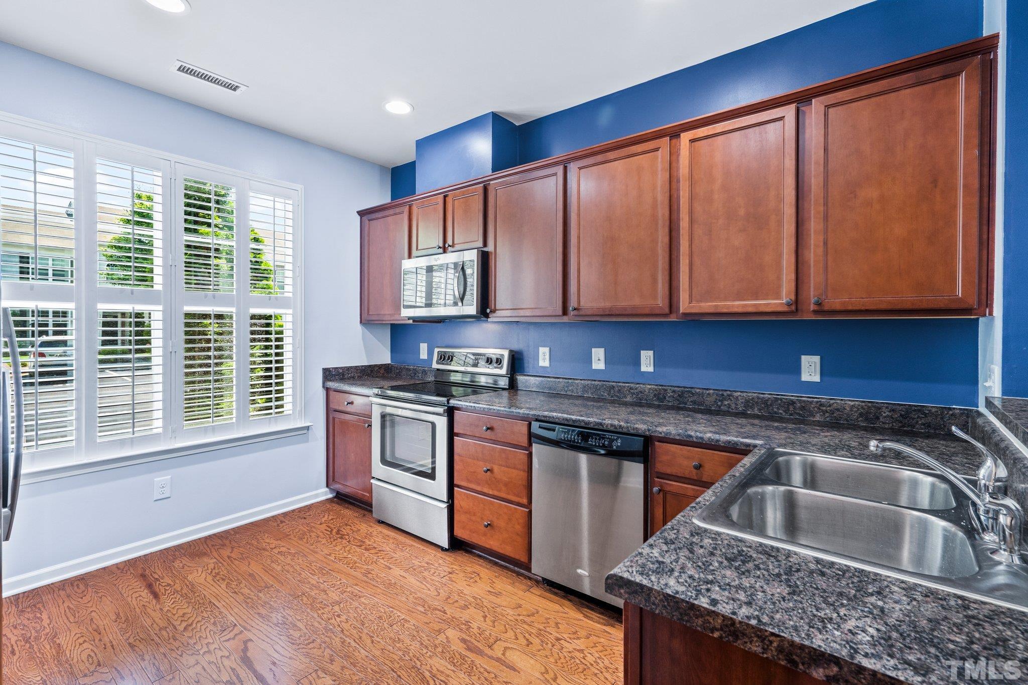 3012 Berkeley Springs Place Raleigh, NC 27616 - Photo 7 of 22 a kitchen with stainless steel appliances granite countertop a sink stove and cabinets