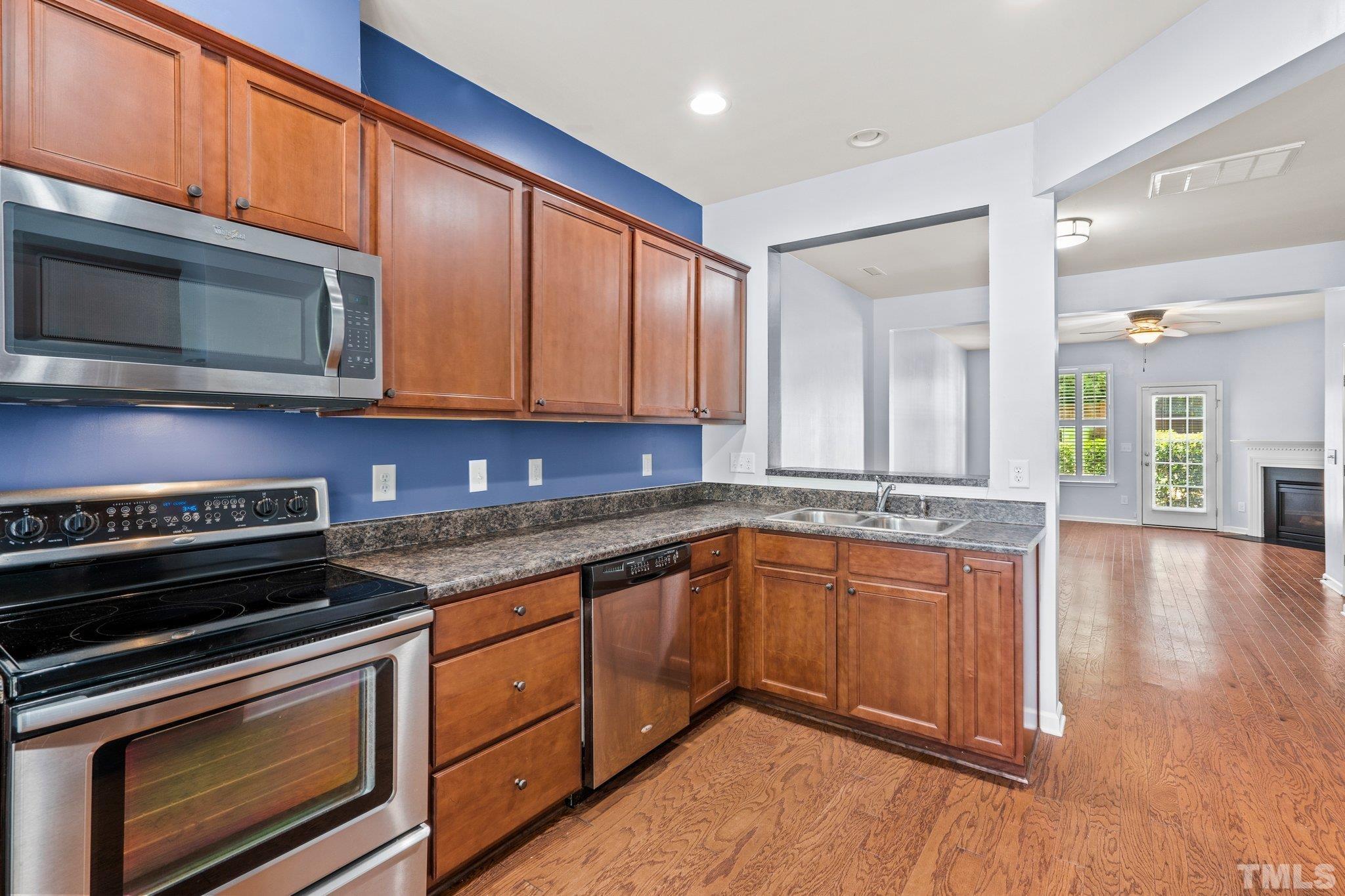 3012 Berkeley Springs Place Raleigh, NC 27616 - Photo 8 of 22 a kitchen with stainless steel appliances granite countertop wooden cabinets and a stove top oven