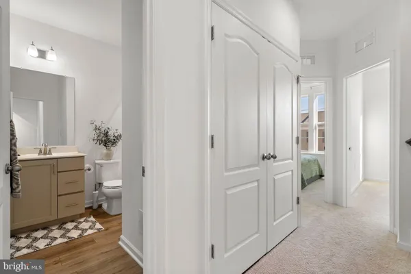 a spacious bathroom with a double vanity sink a toilet and a mirror