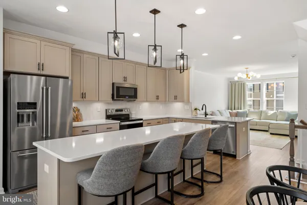 a kitchen with stainless steel appliances granite countertop a kitchen island a stove a table and chairs