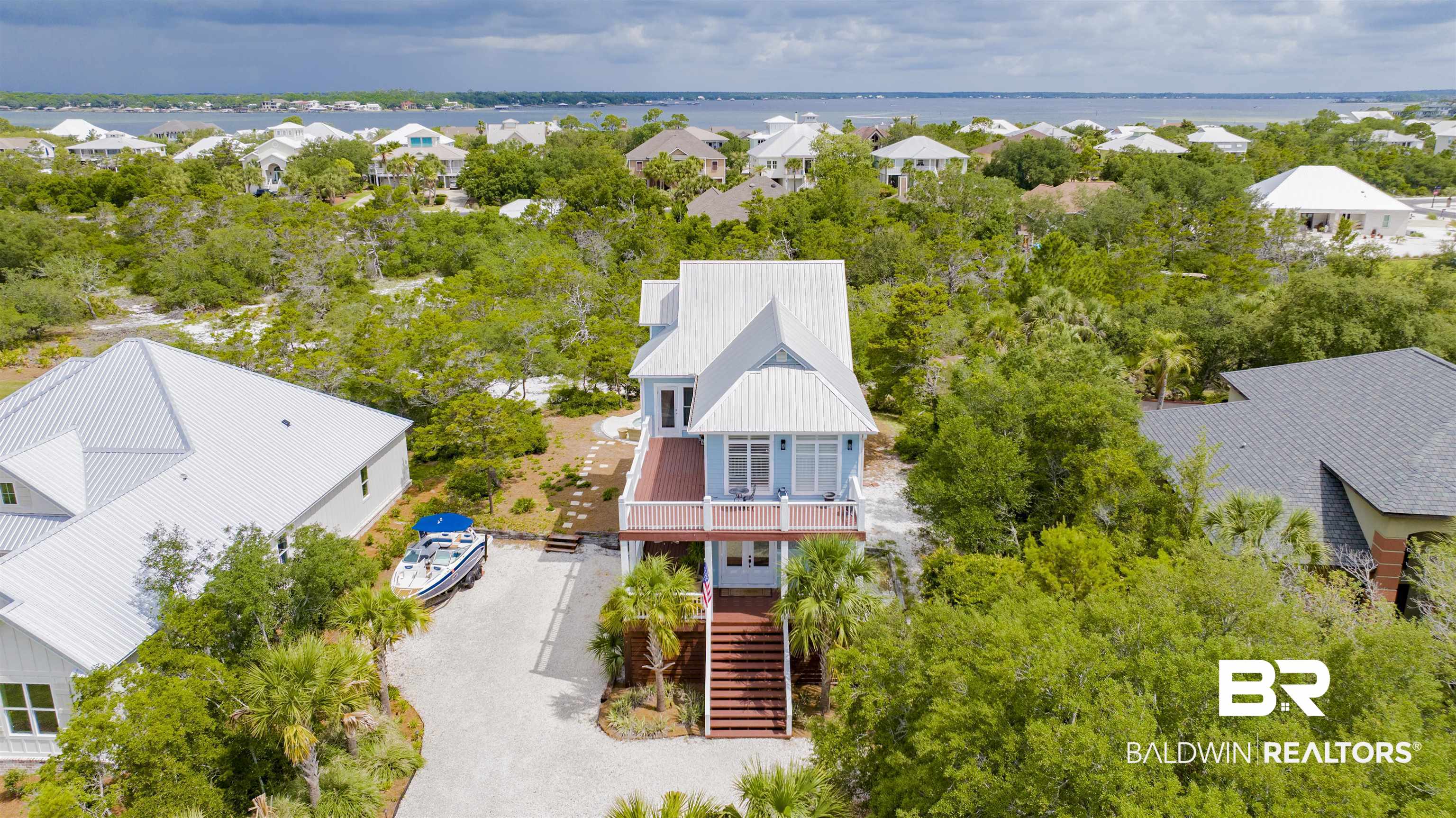 30351 River Road Orange Beach, AL 36561 - Photo 37 of 44 Elevated coastal residence featuring a light blue exterior, white trim, and a metal roof