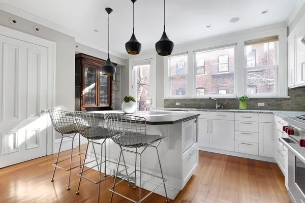 a kitchen with stainless steel appliances granite countertop a stove a sink and a wooden floors
