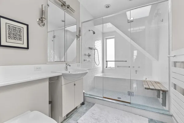 a spacious bathroom with a shower sink and mirror