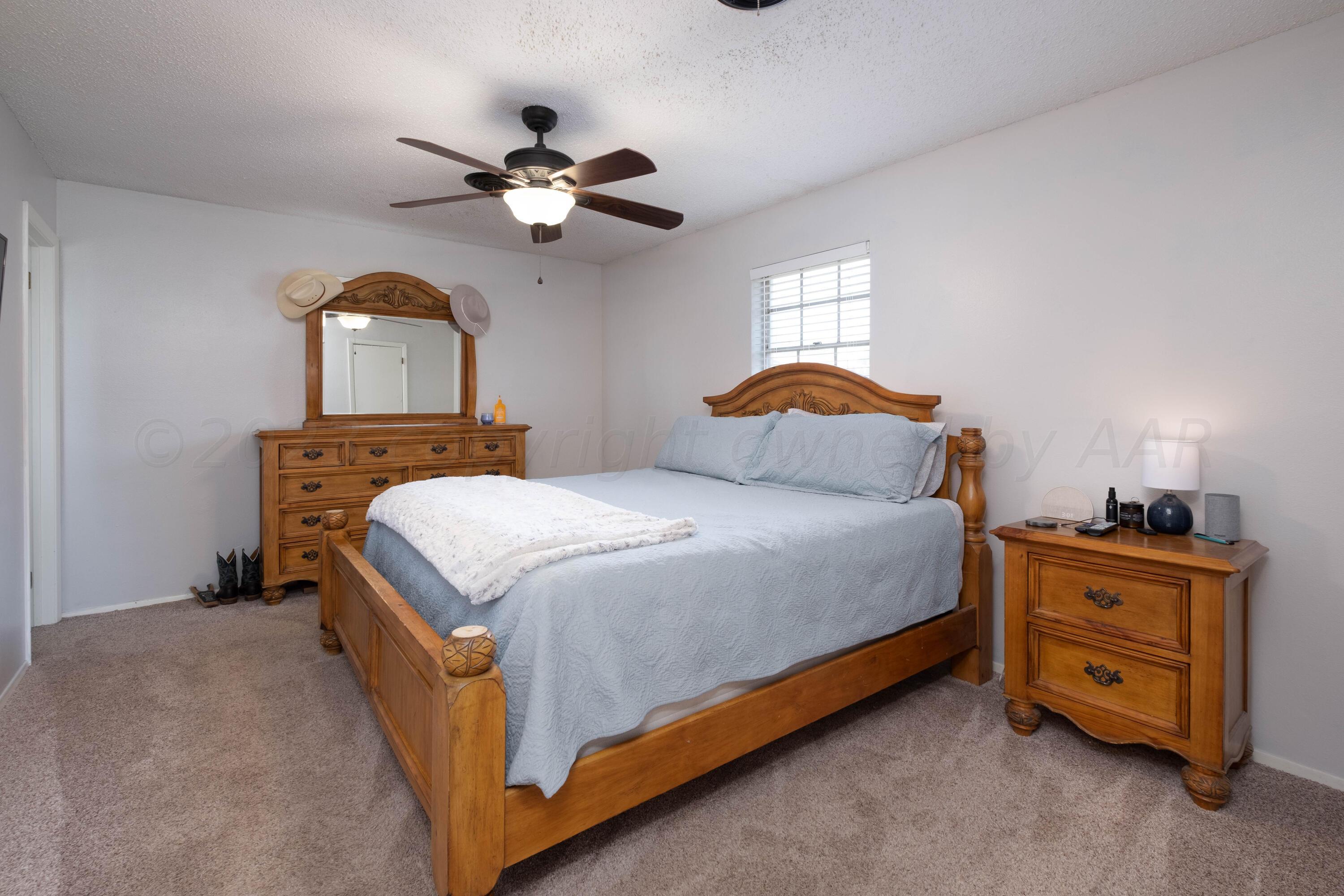 4813 South Rusk Street Amarillo, TX 79110 - Photo 15 of 23 a bedroom with a bed and a chandelier