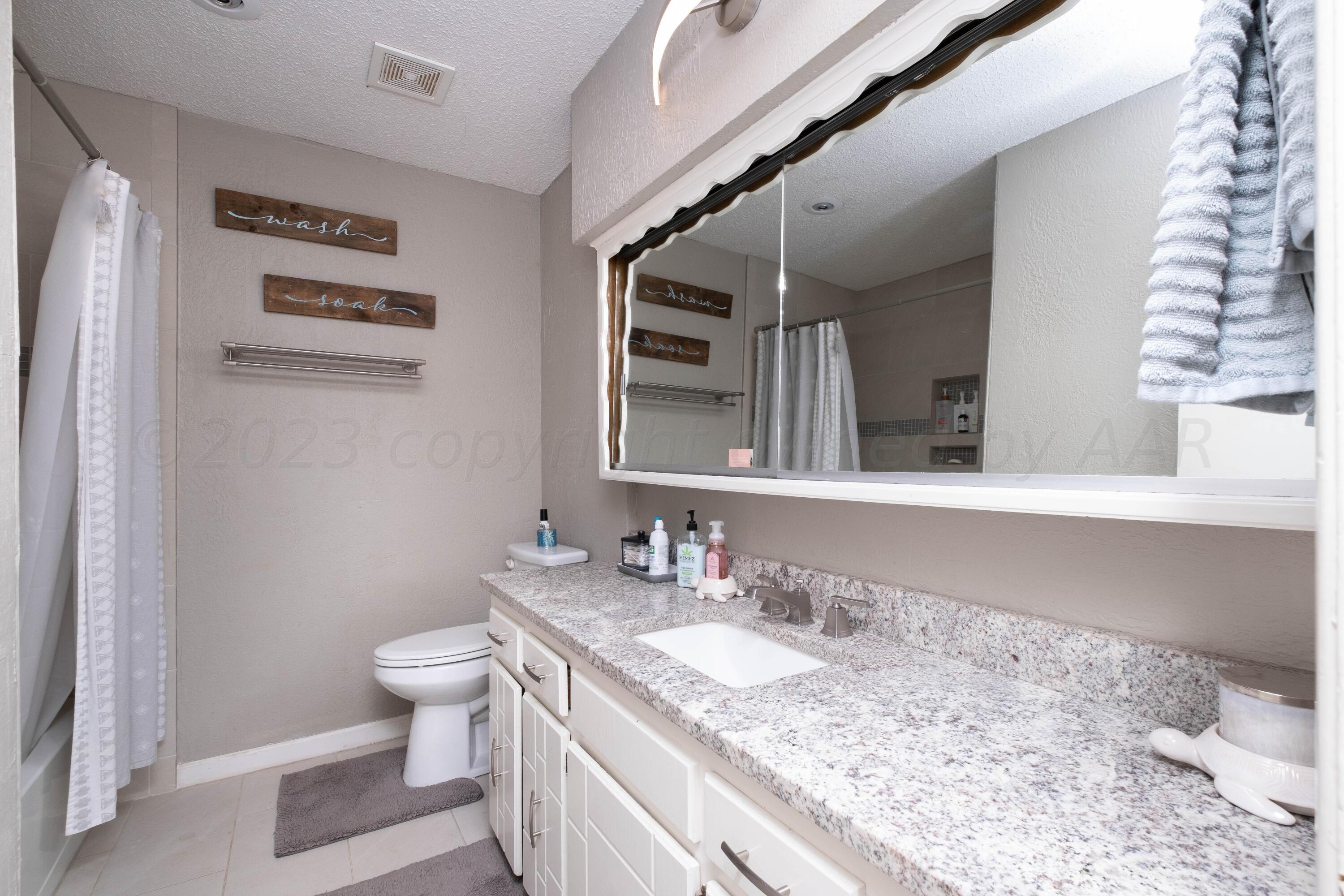 4813 South Rusk Street Amarillo, TX 79110 - Photo 18 of 23 a bathroom with a granite countertop sink and a mirror