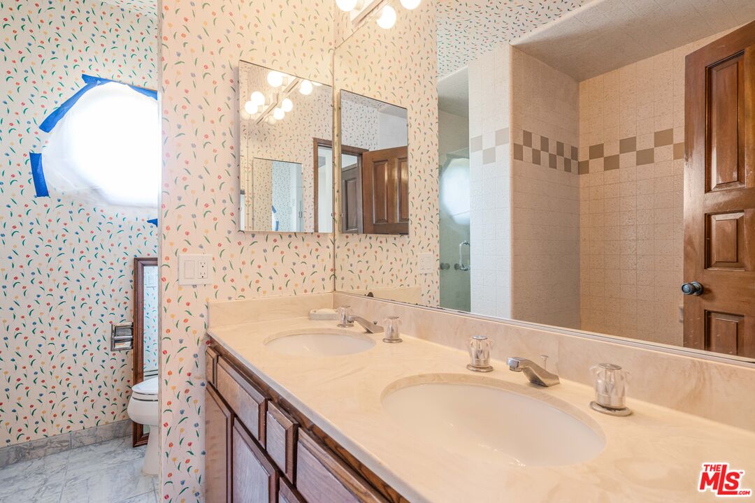 1181 Somera Road Los Angeles, CA 90077 - Photo 23 of 40 a bathroom with a double vanity sink mirror and toilet