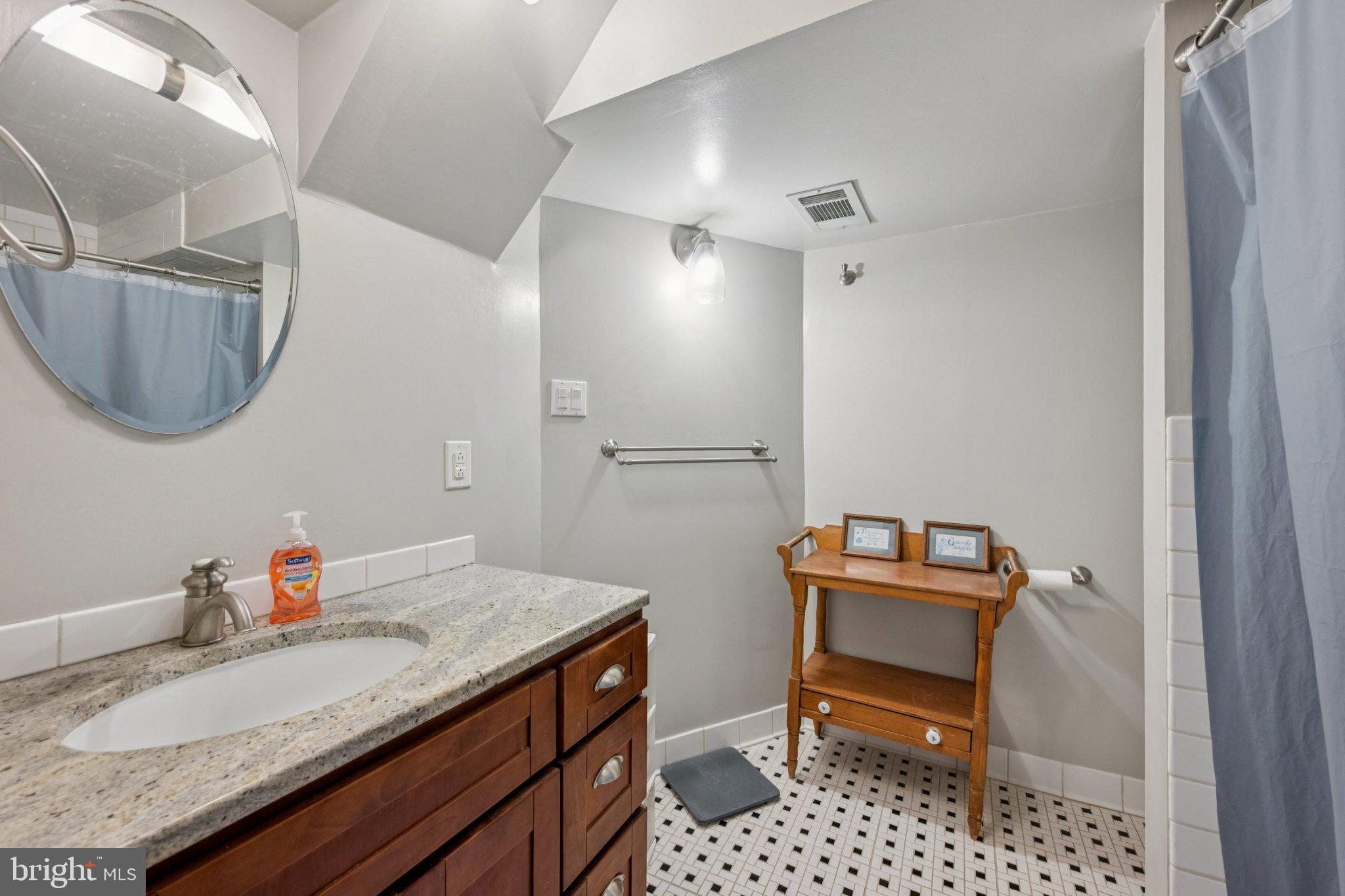 2307 Cheverly Avenue Cheverly, MD 20785 - Photo 14 of 25 a bathroom with a sink a toilet and a mirror