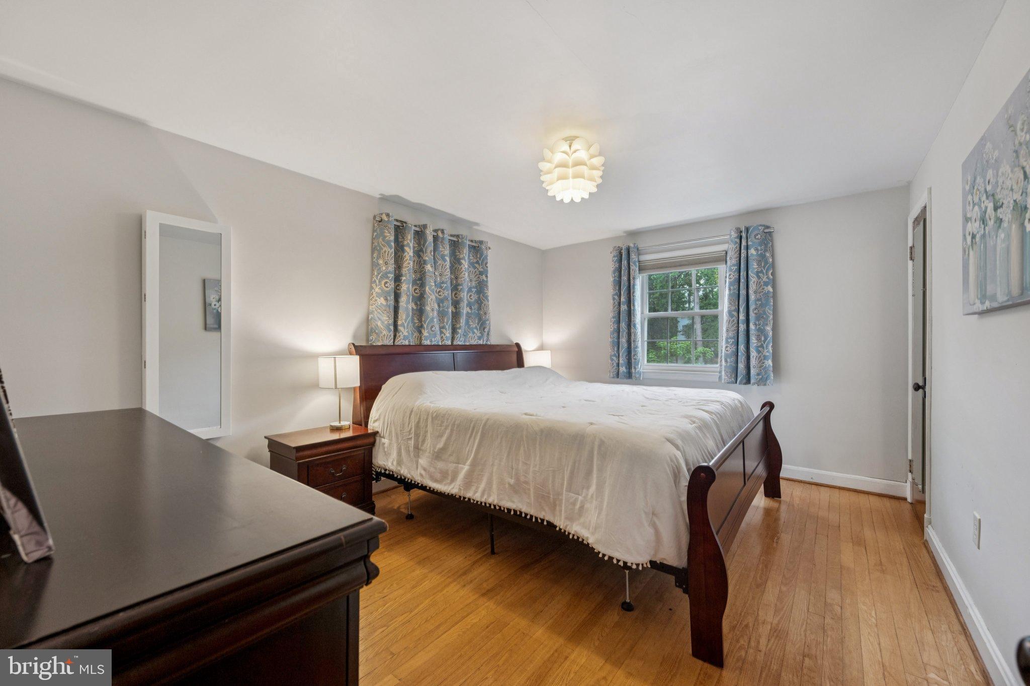 2307 Cheverly Avenue Cheverly, MD 20785 - Photo 20 of 25 a bedroom with a bed and a table in it with wooden floor