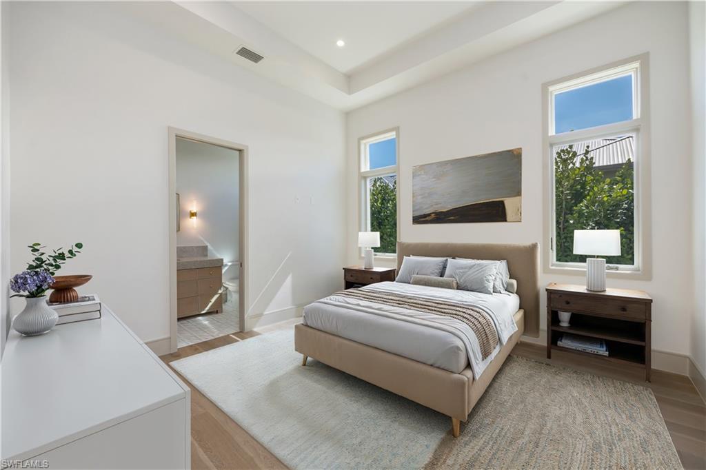4851 Crayton Road Naples, FL 34103 - Photo 22 of 33 a bedroom with a bed and a chandelier