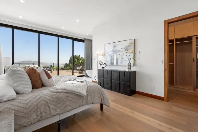 a bedroom with a bed and a large window