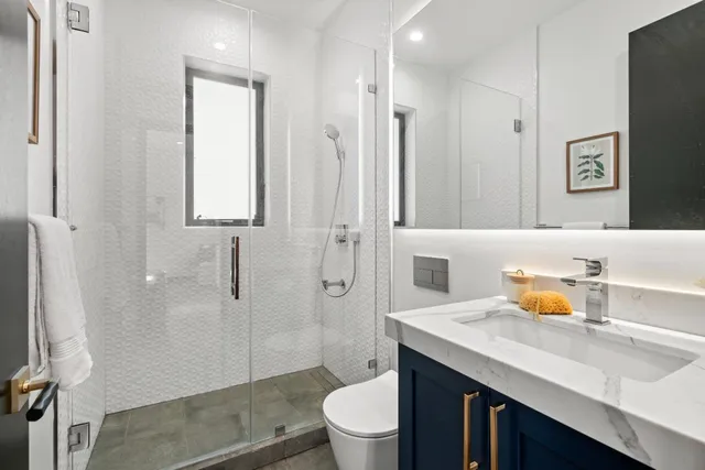 a bathroom with a double vanity sink toilet and shower
