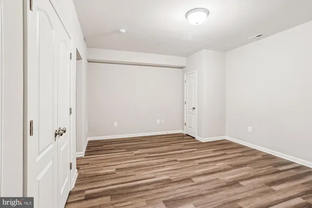 a view of a room with wooden floor and white walls