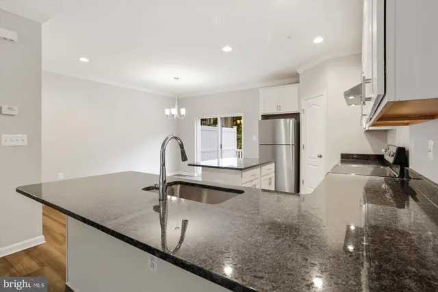 a view of a kitchen with a sink stainless steel appliances and cabinets