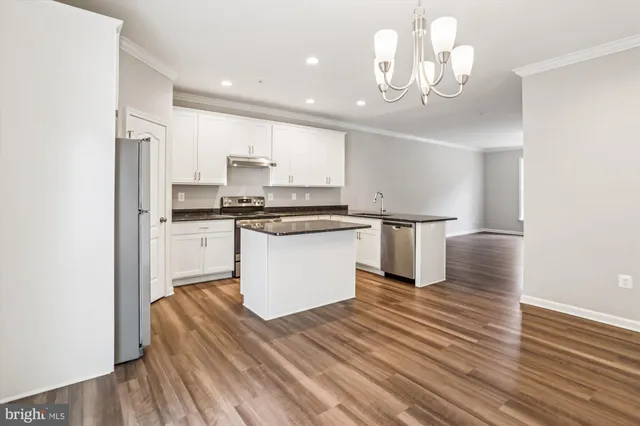 a kitchen with wooden floors and white cabinets