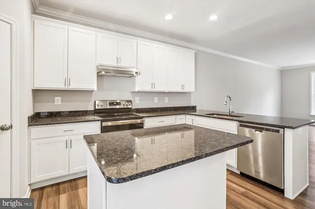 a kitchen with stainless steel appliances granite countertop a sink stove and cabinets