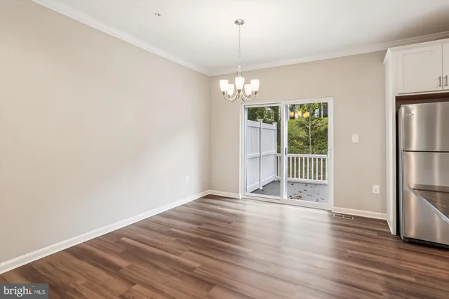 a view of a hallway with wooden floor and a chandelier