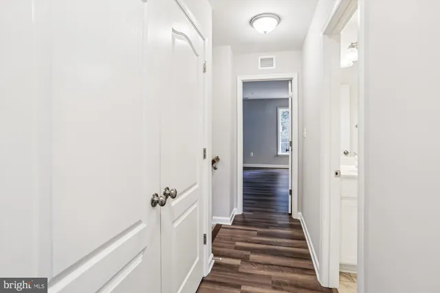 a view of a hallway with wooden floor and entryway