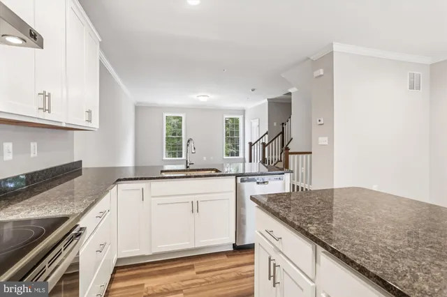 a kitchen with granite countertop a sink stove and cabinets