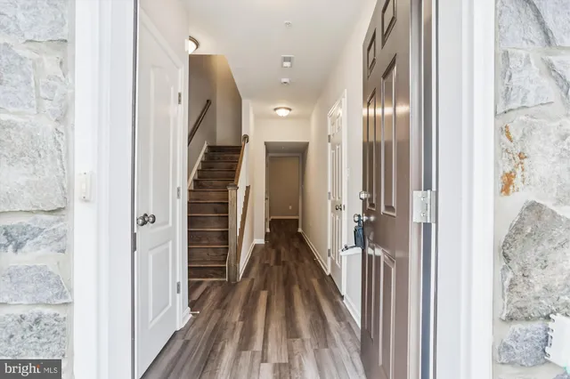 a view of a hallway with wooden floor and staircase