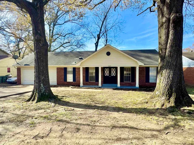 a view of a house with a tree in front of it