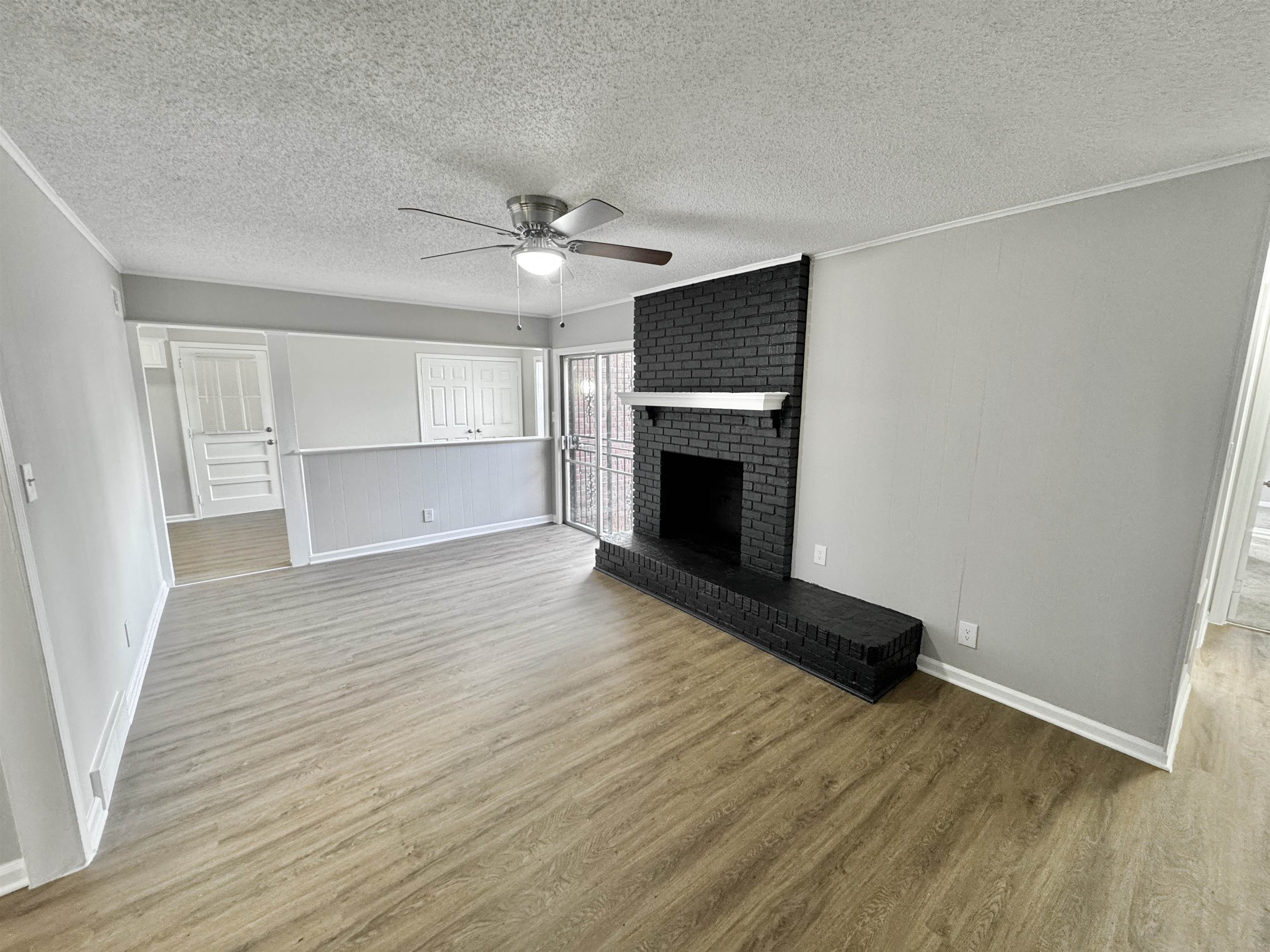 3429 Clarke Road Memphis, TN 38115 - Photo 3 of 33 a view of an empty room with wooden floor fireplace and a window