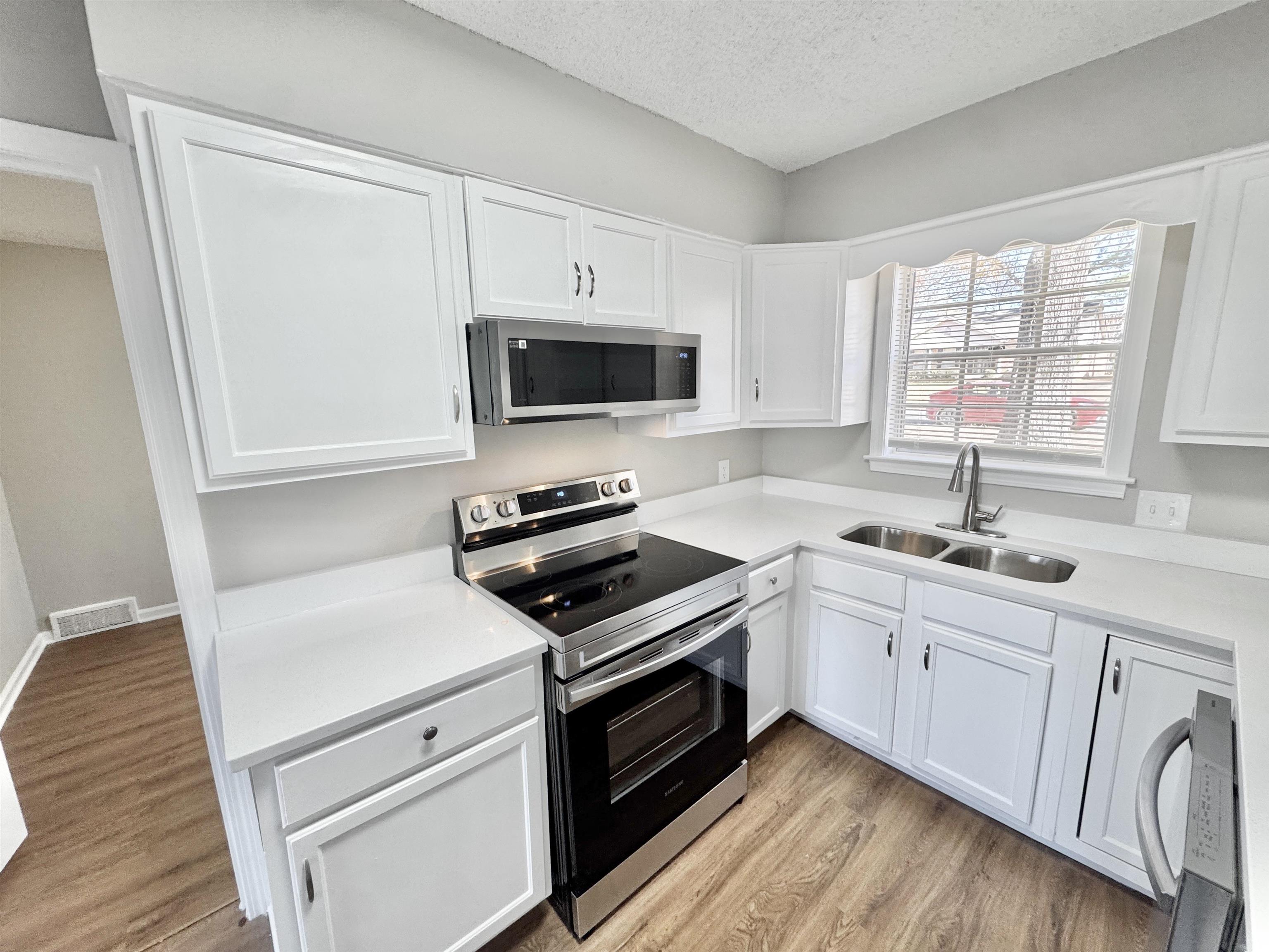 3429 Clarke Road Memphis, TN 38115 - Photo 8 of 33 a kitchen with white cabinets and appliances