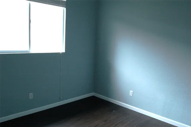 an empty room with a closet and wooden floor