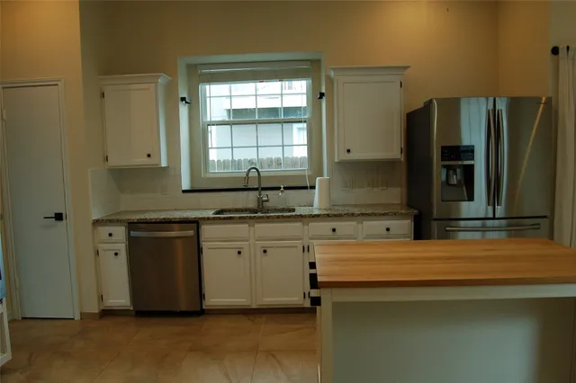 a kitchen with stainless steel appliances granite countertop a sink and a refrigerator