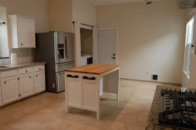 a kitchen with stainless steel appliances granite countertop a stove a sink and a refrigerator