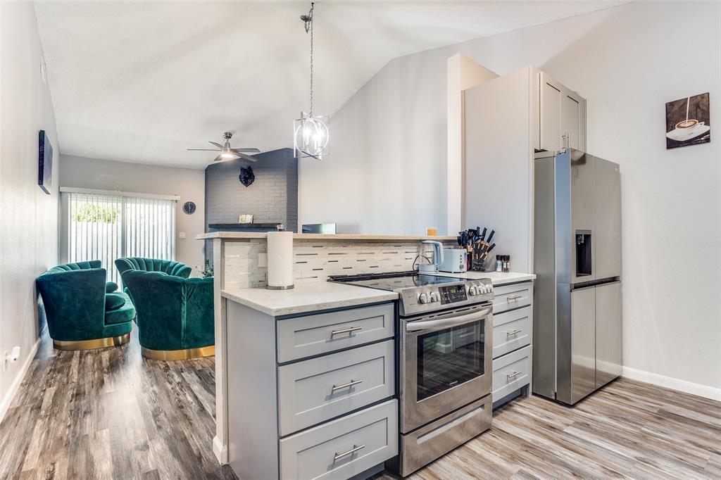 3801 14th Street, Unit 502 Plano, TX 75074 - Photo 3 of 12 a kitchen with stainless steel appliances granite countertop a stove and a refrigerator