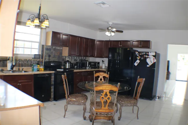 a kitchen view of dining table chairs and chandelier