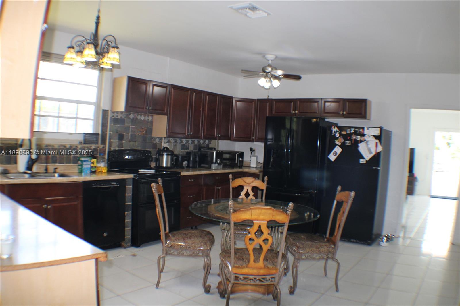 35000 Southwest 212th Avenue Homestead, FL 33034 - Photo 10 of 11 a kitchen view of dining table chairs and chandelier