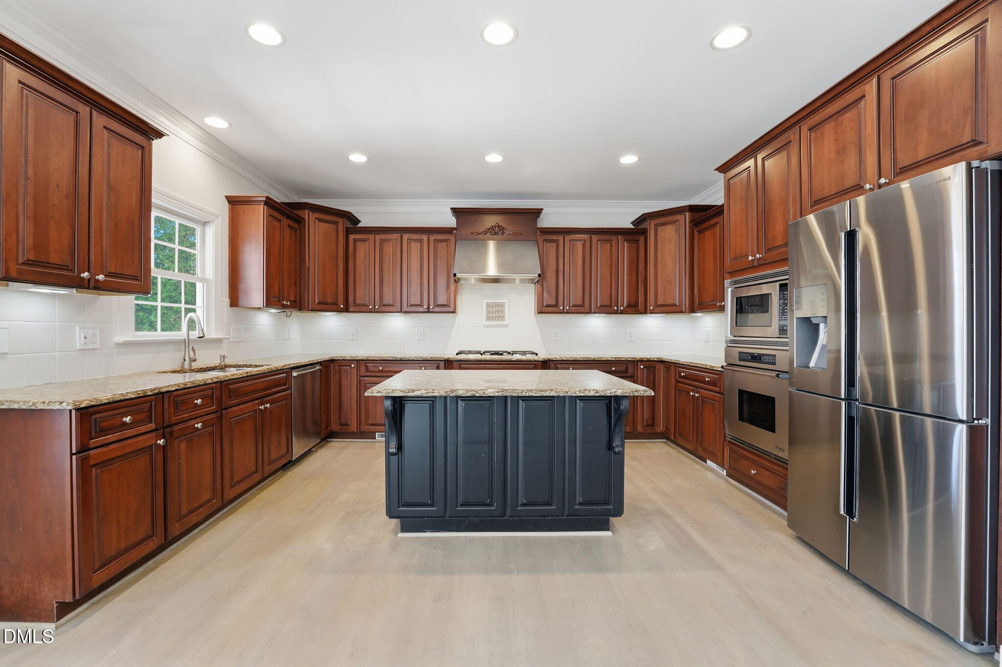 2900 SnapsWell Street Raleigh, NC 27614 - Photo 11 of 40 a kitchen with kitchen island granite countertop wooden cabinets a sink and stainless steel appliances