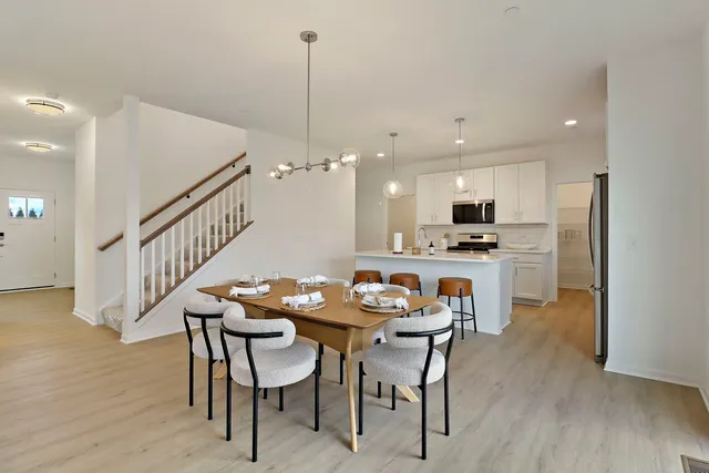 a dining room with furniture and kitchen view